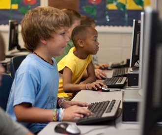 Children working on computers in a classroom